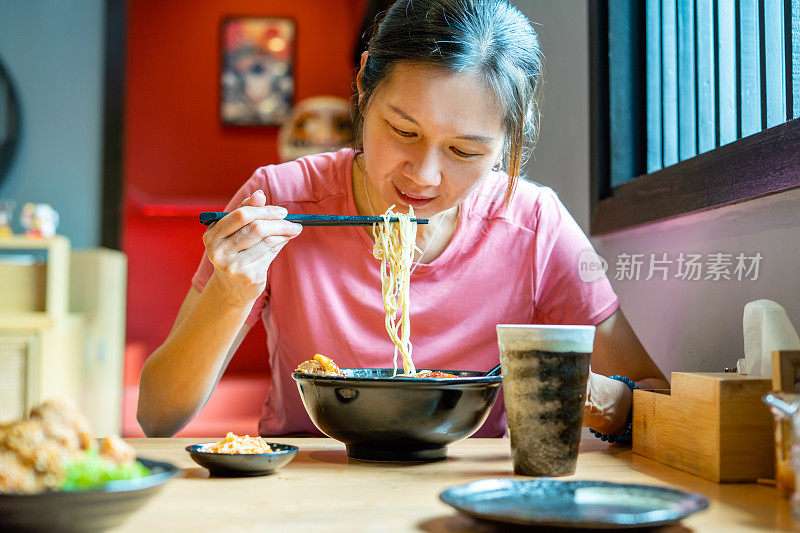 一名女子在日本餐厅享用日式拉面/面汤
